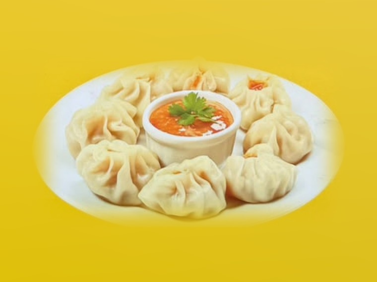 A plate of steamed momo with tomato achar