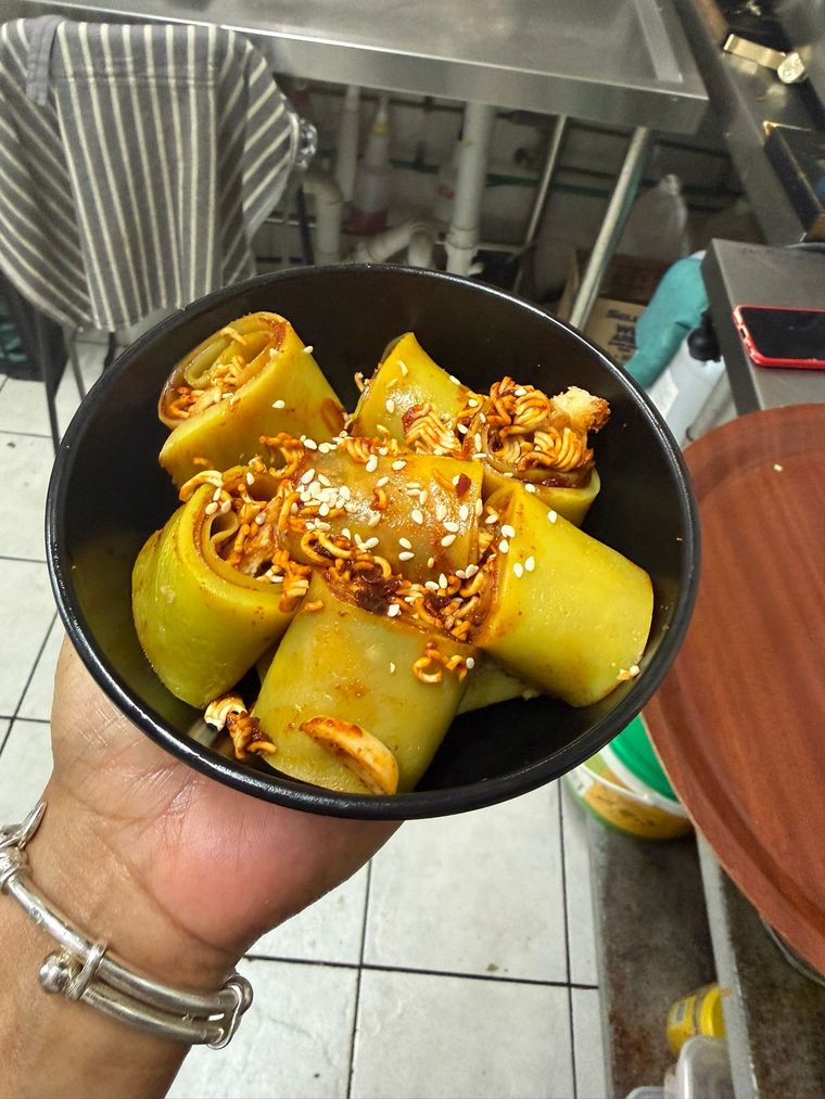 Rolled laphing topped with chilli sauce, crushed noodles and sesame seeds