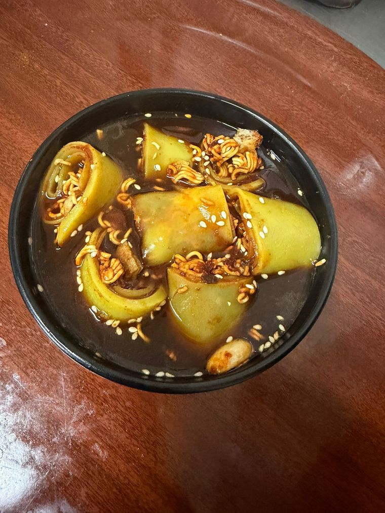 Laphing rolls in a dark spiced broth with sesame and crunchy noodles