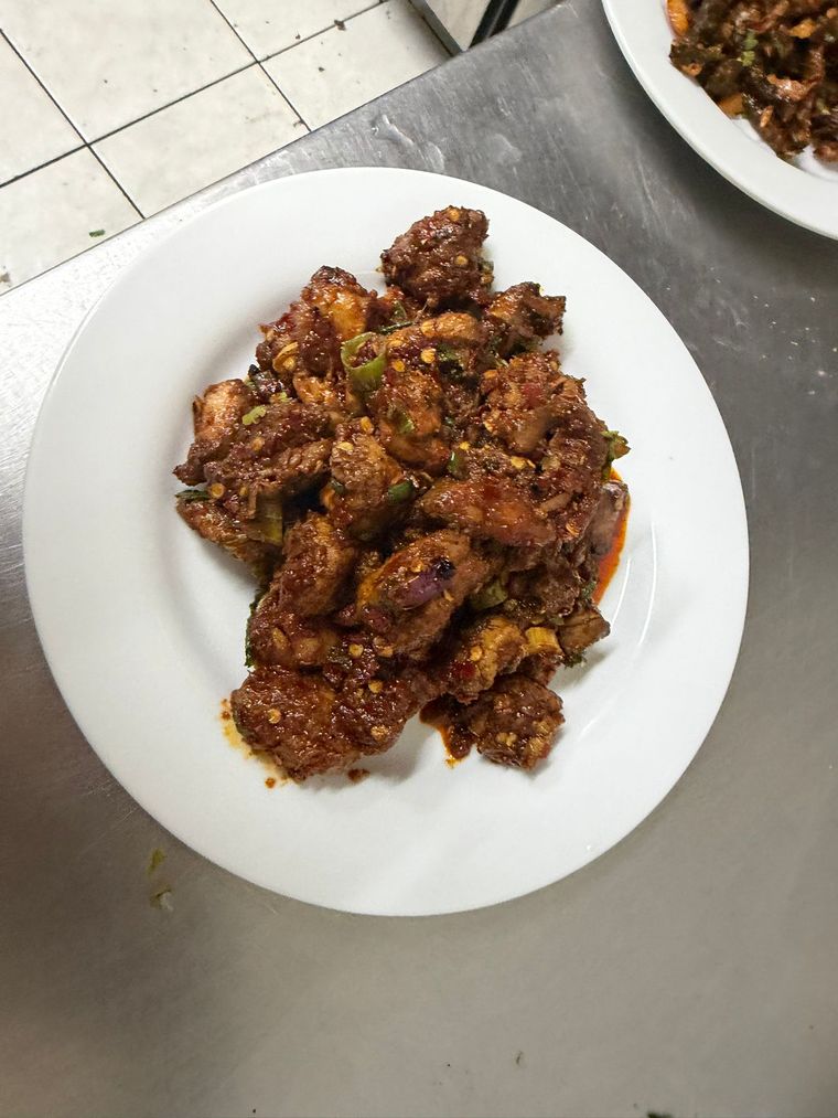 Plate of crispy chicken chilli tossed in a dark chilli glaze