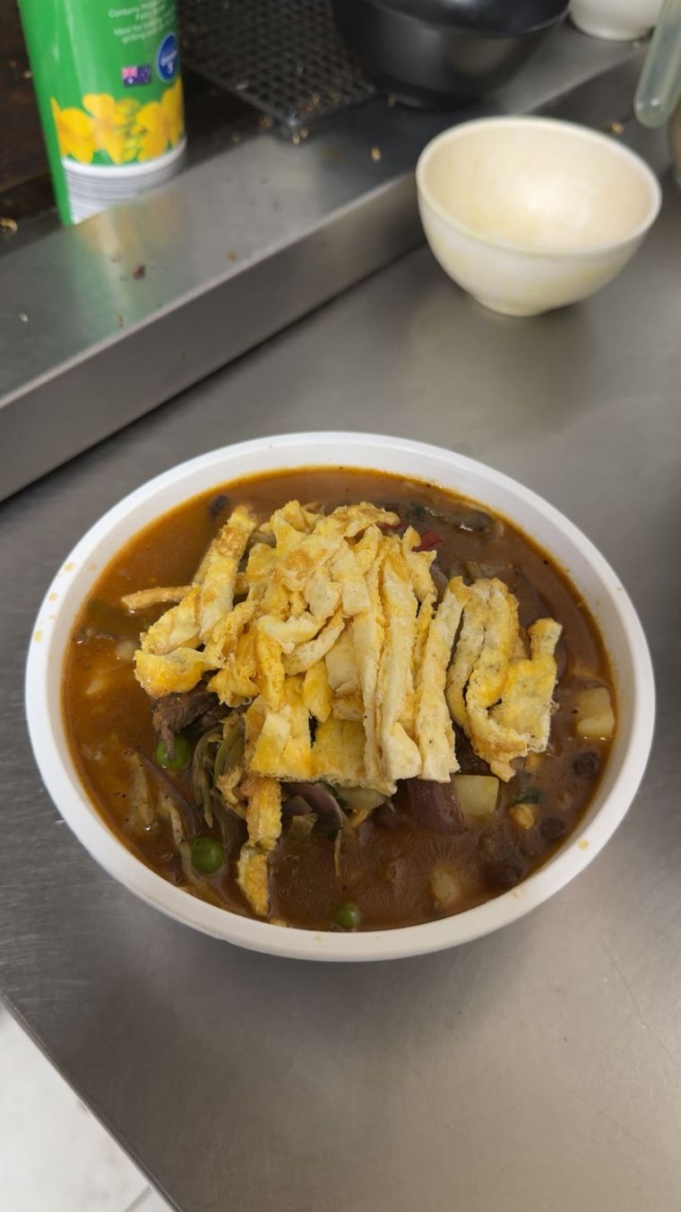Bowl of thukpa noodle soup topped with shredded omelette