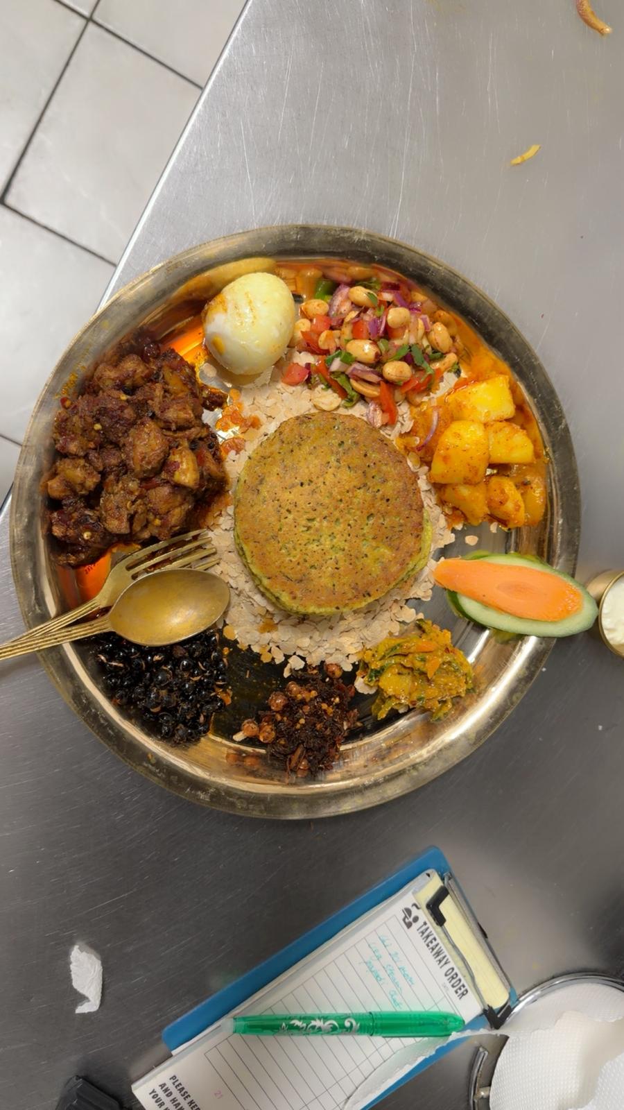 Brass thali khaja set with beaten rice, choila, soybeans, potato and pickles