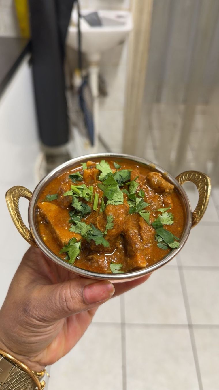Karahi bowl of goat curry finished with fresh coriander