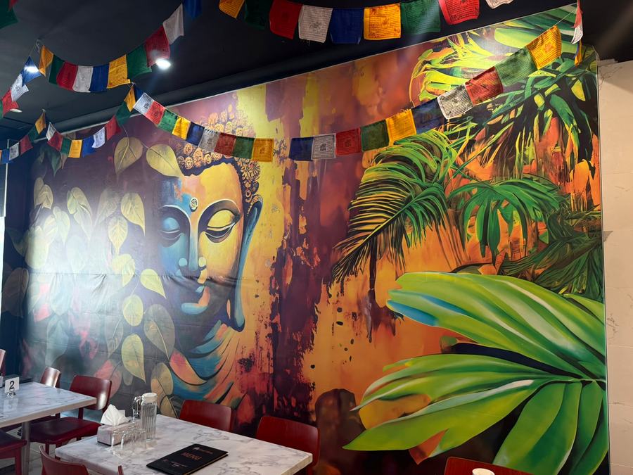 The hand-painted Buddha mural and prayer flags inside Momo's Hunt