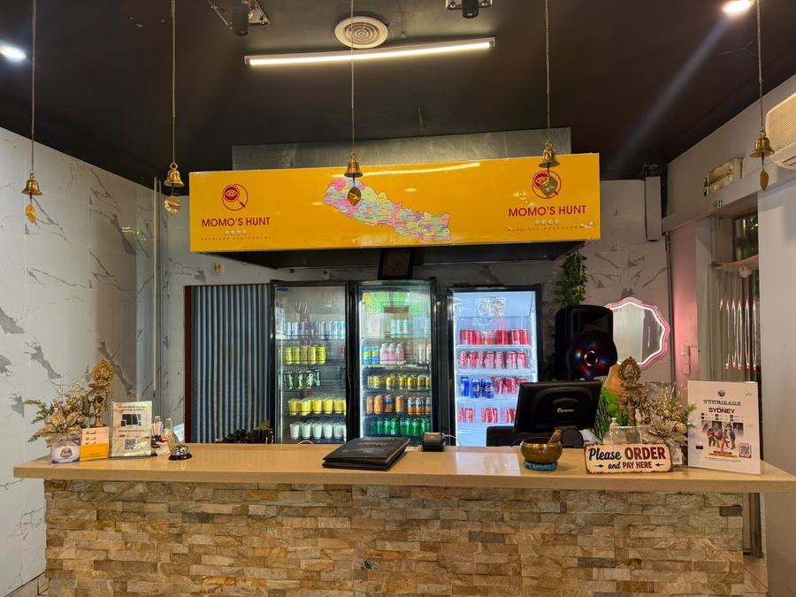 Order counter with the Momo's Hunt sign, brass bells and drink fridges